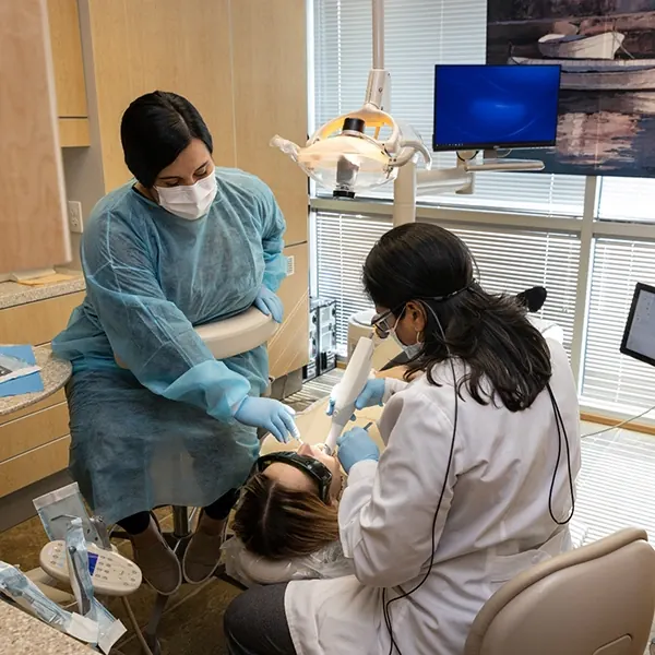 Two of our dentists working on a patient's smile.