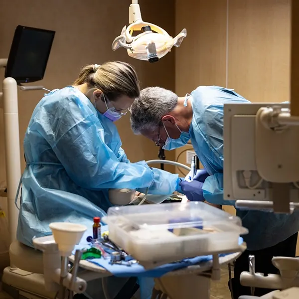 Dr. Williams treating a patient with an assistant beside him.